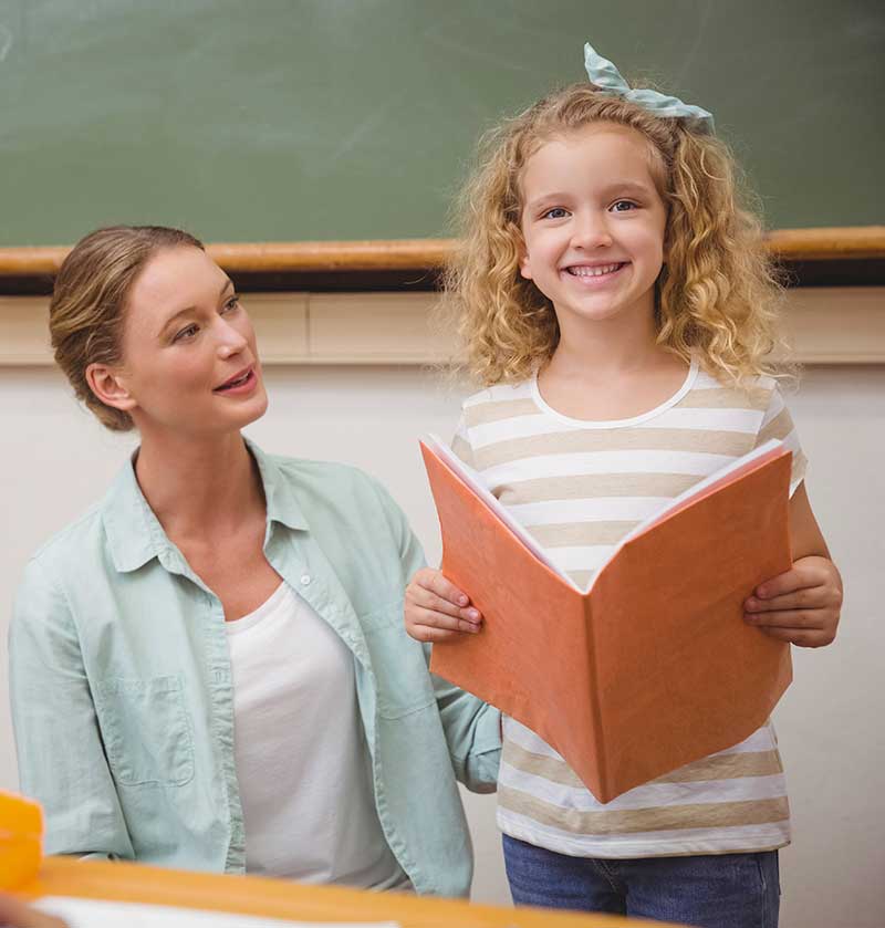 Girl reading with teacher